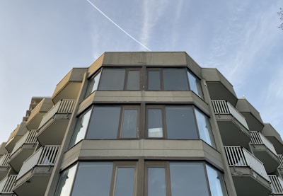 Modern glass-fronted apartment building overlooking a bustling city street.