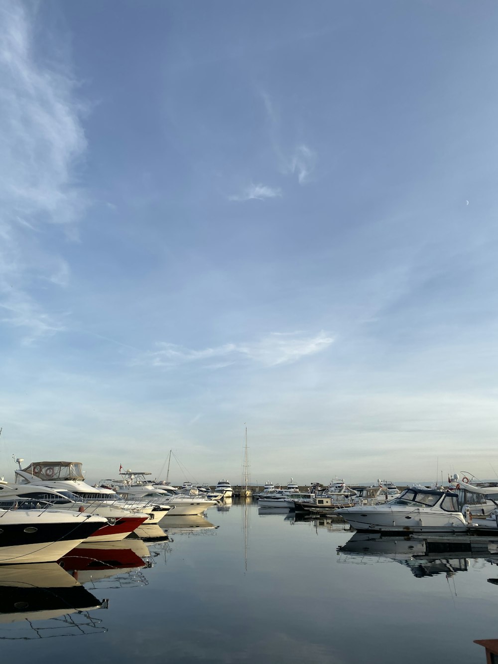 a marina filled with lots of boats under a blue sky