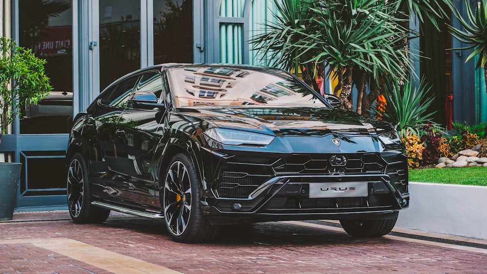 black car parked beside building and plants