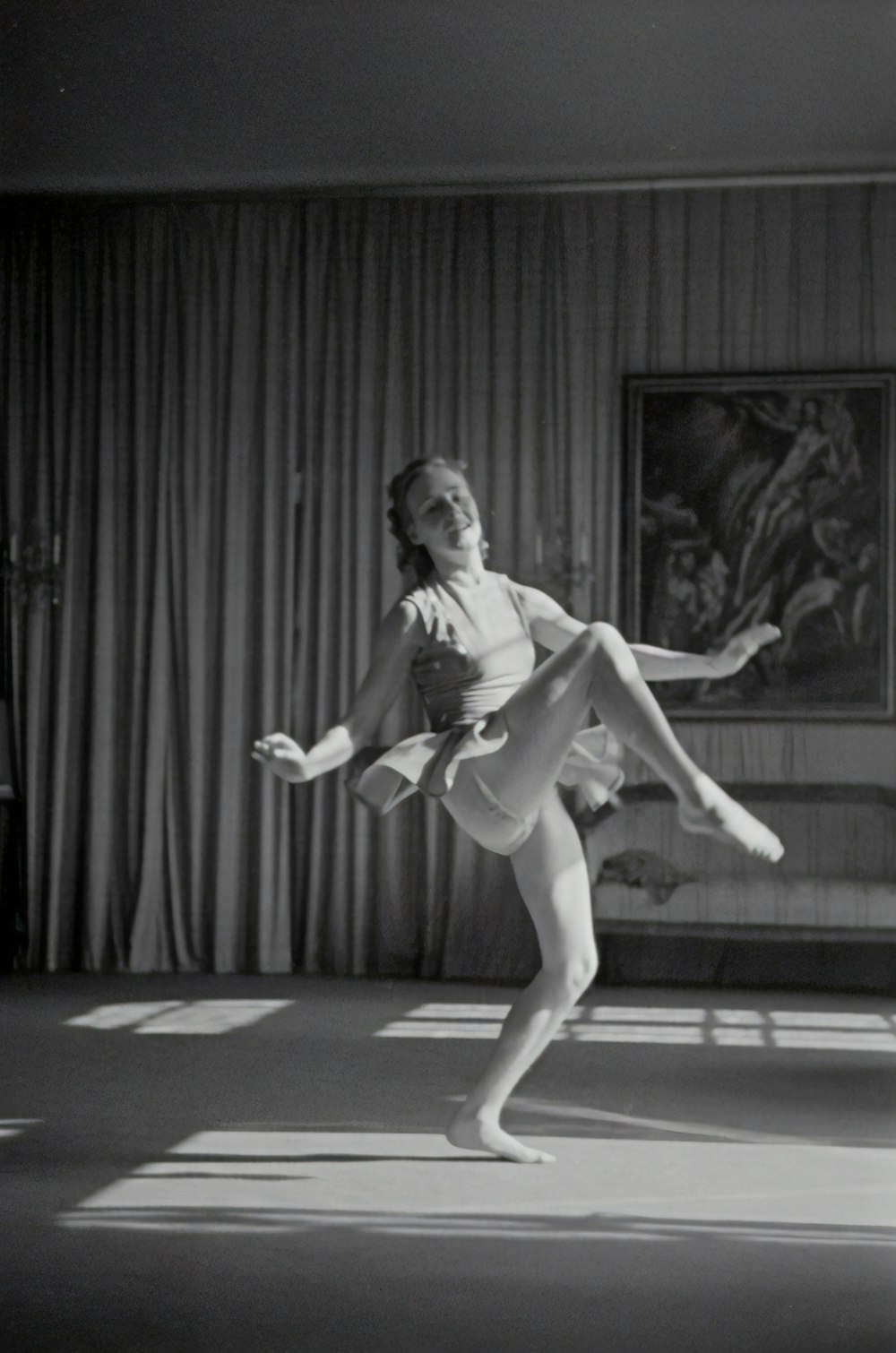 Graustufenfoto einer Frau, die in der Nähe des Vorhangs tanzt