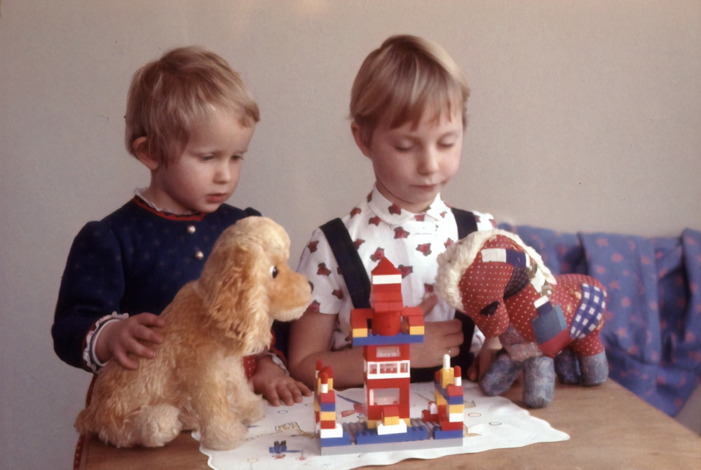 Dos niños jugando juguetes en la mesa