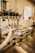 A close-up view of an industrial machine component featuring multiple metal pipes and mechanical parts. Various cables are connected, and the setting appears to be a factory or manufacturing environment. The image has a warm, metallic look with reflections off the metal surfaces.