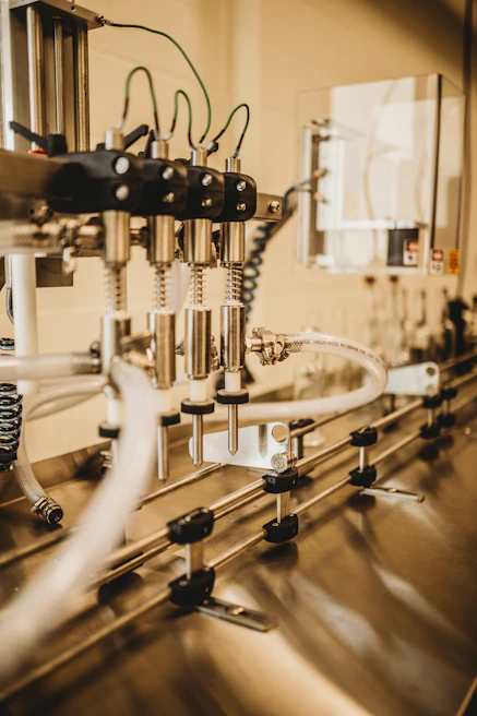 Close-up of a technician connecting sensors on a factory machine for IoT integration.