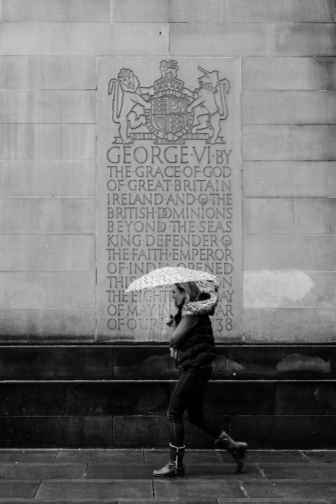 grayscale photo of woman with umbrella walking on street