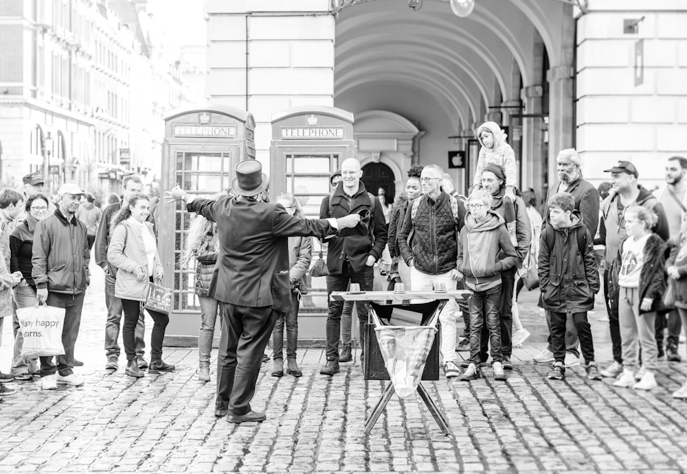 Photo en niveaux de gris de personnes marchant sur le trottoir