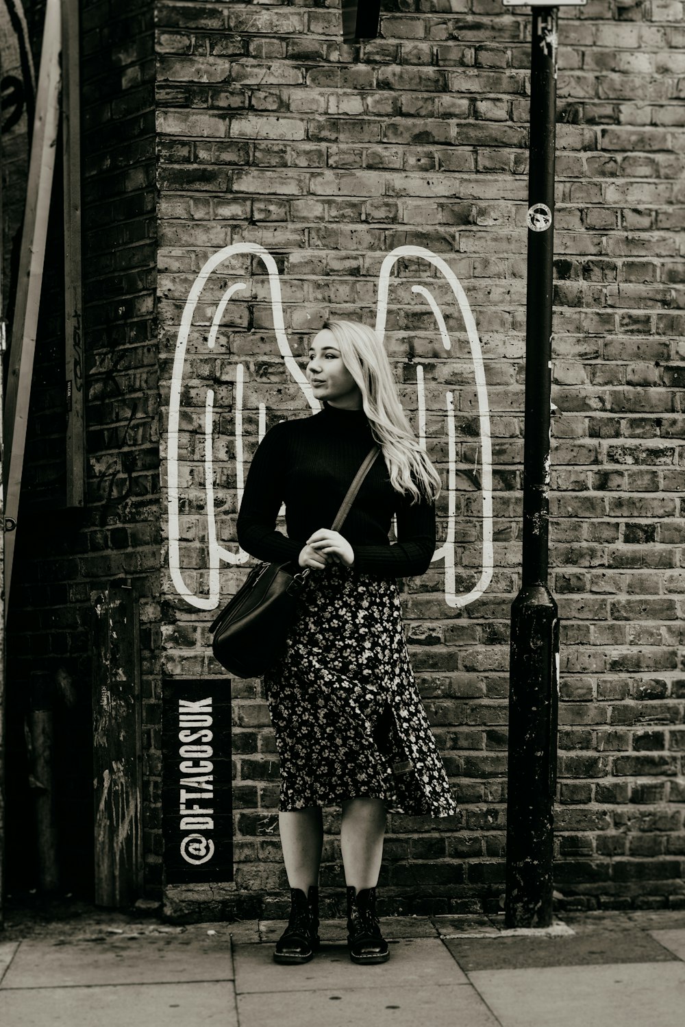 grayscale photo of woman standing looking at right side