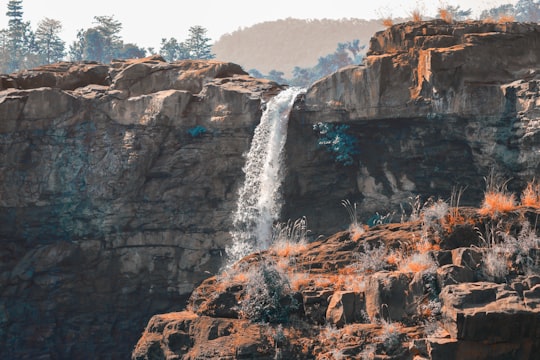 rocky mountain waterfalls during day in Saputara India
