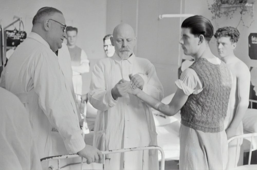 grayscale photography of man in lab gown