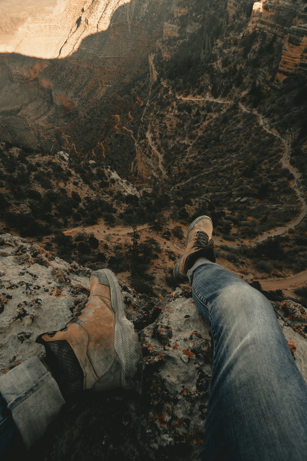 personne assise sur une montagne rocheuse pendant la journée