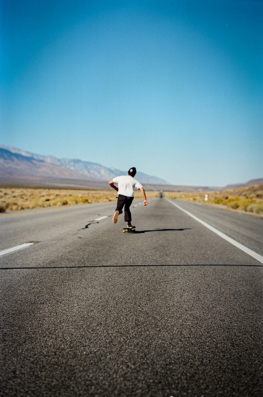 person skating in the middle of the road during daytimer