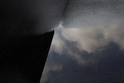 Sealed cistern with a glossy white waterproofing finish, reflecting the surrounding blue sky.