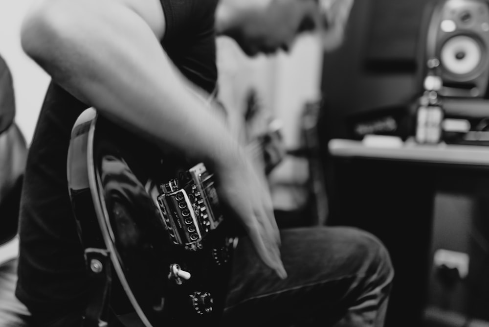 man playing guitar grayscale photo