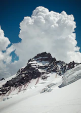 A rugged mountain peak under a stormy sky symbolizing strength and perseverance.
