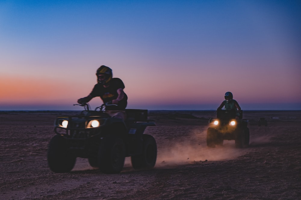two persons on all-terrain vehicles