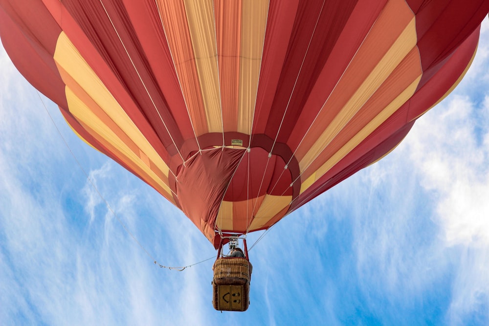 red and yellow hot air balloon floating on air