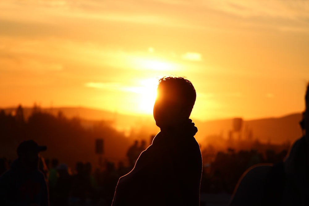 silhouette of person facing sun during golden hour