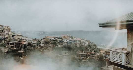 aerial photography of houses and buildings viewing mountain in foggy day in Irisan Philippines