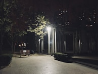 Evening scene of a park bench with an SS Phone Charging station illuminated, ready for use.