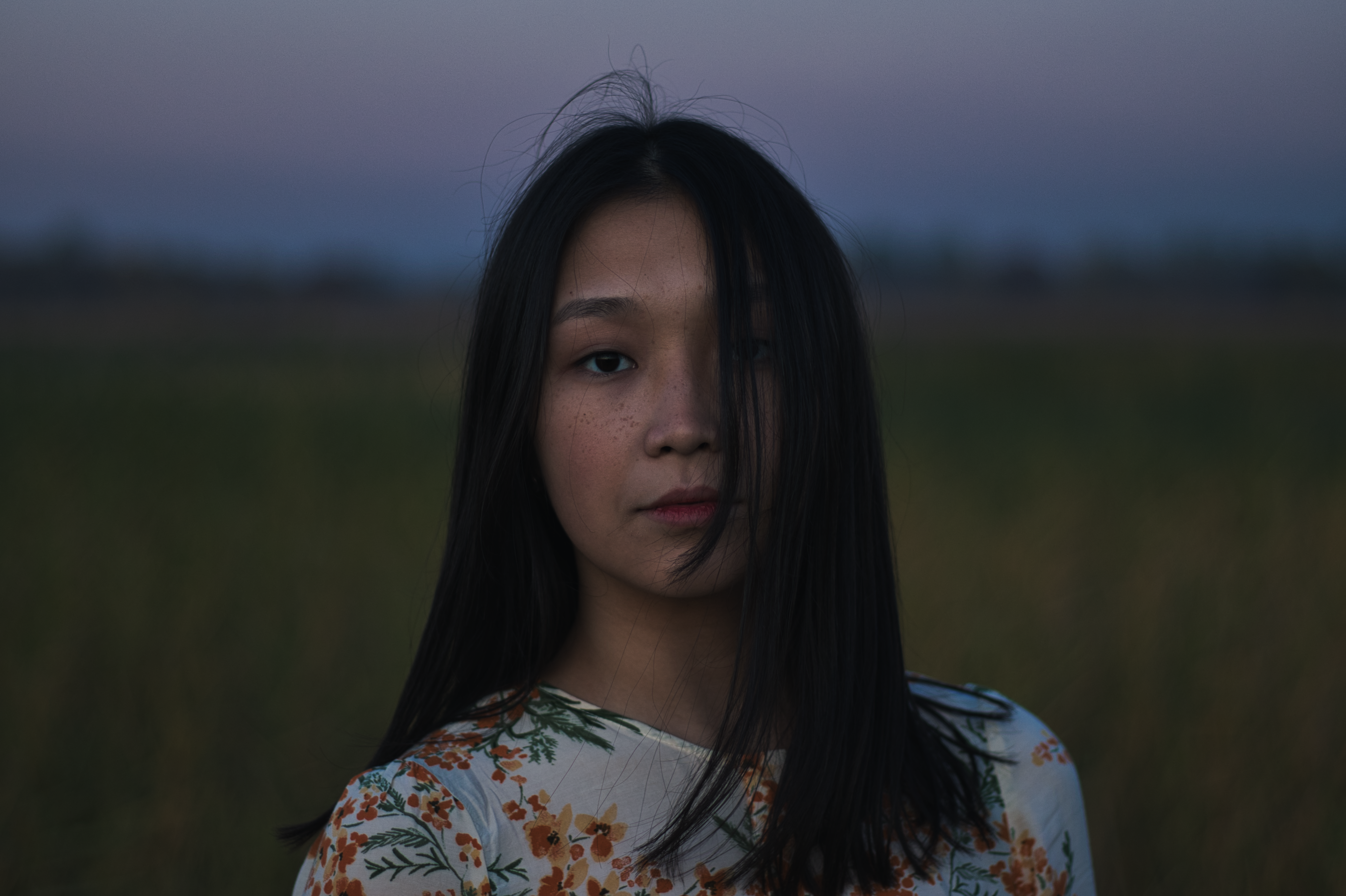 selective focus photography of woman in floral blouse at field