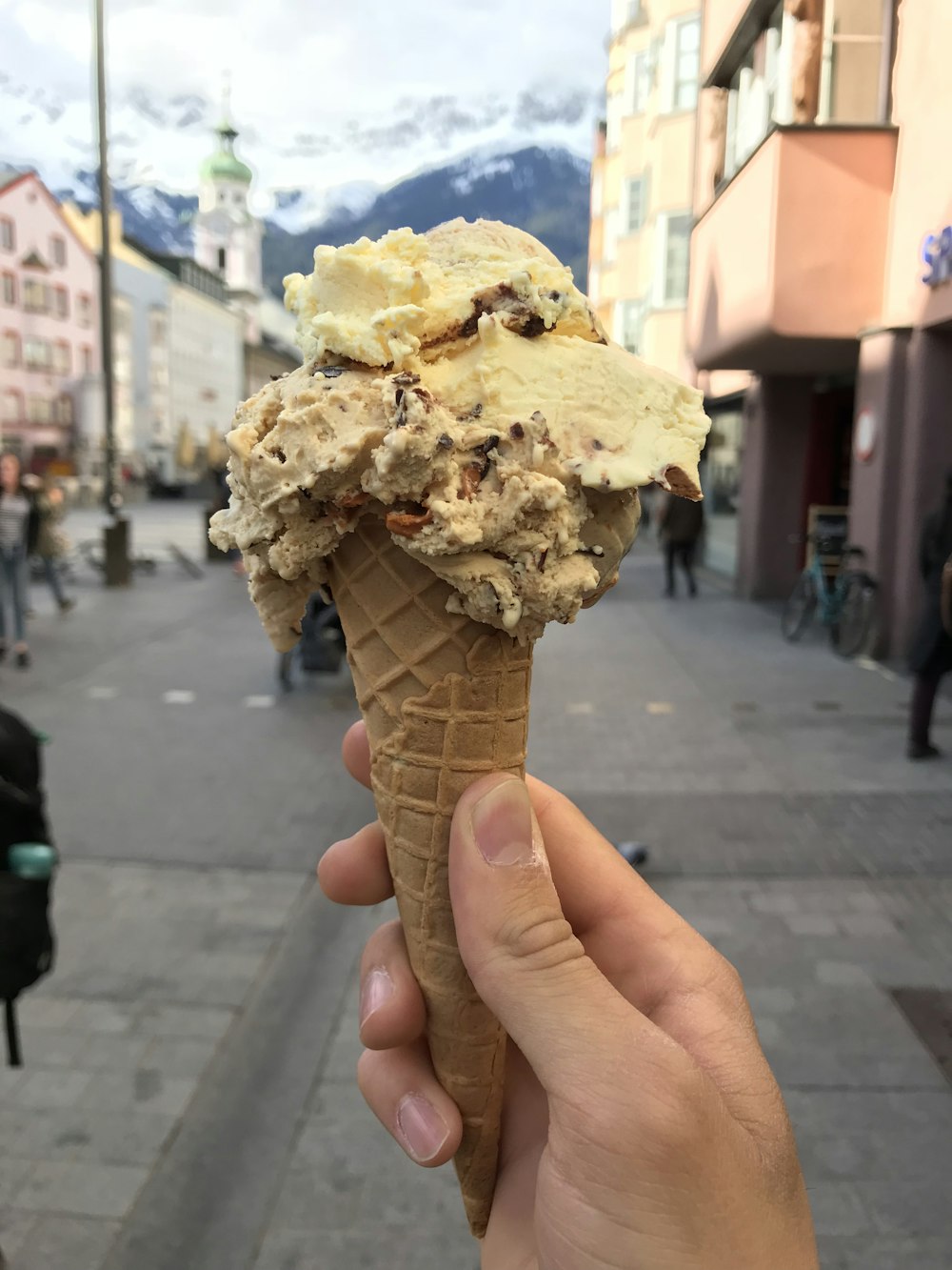 person holding ice cream with cone