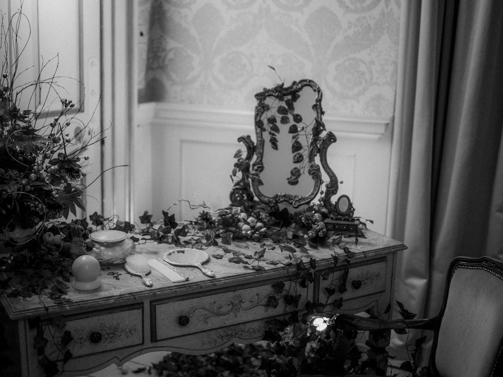 grayscale photo of mirror and comb on desk