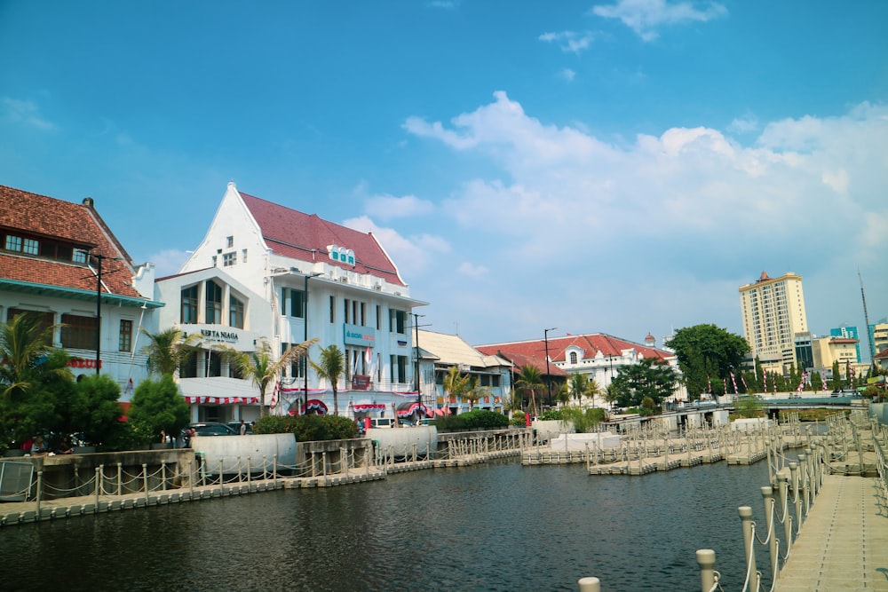 white and red concrete building beside body of water during daytime