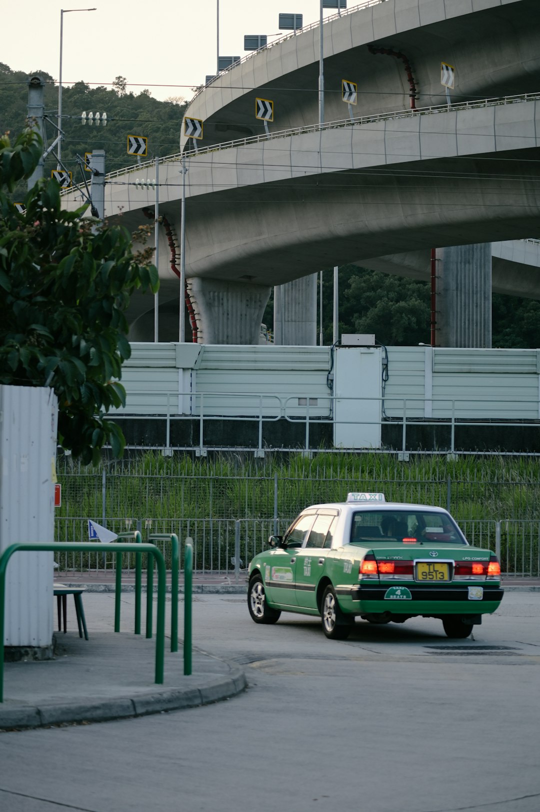 green sedan beside concrete building during daytime