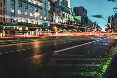 time lapse photo of cars passing by buildings during nighttiem