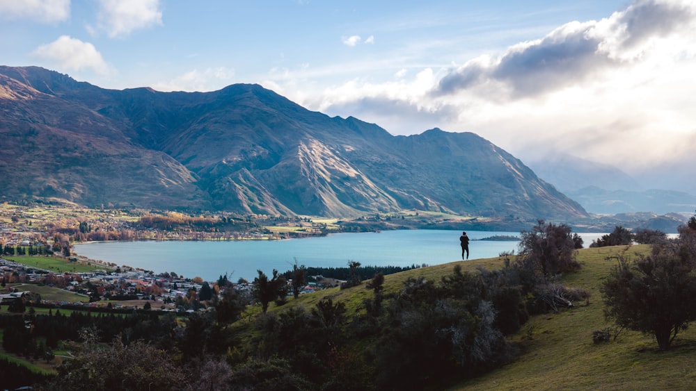 a person standing on top of a lush green hillside