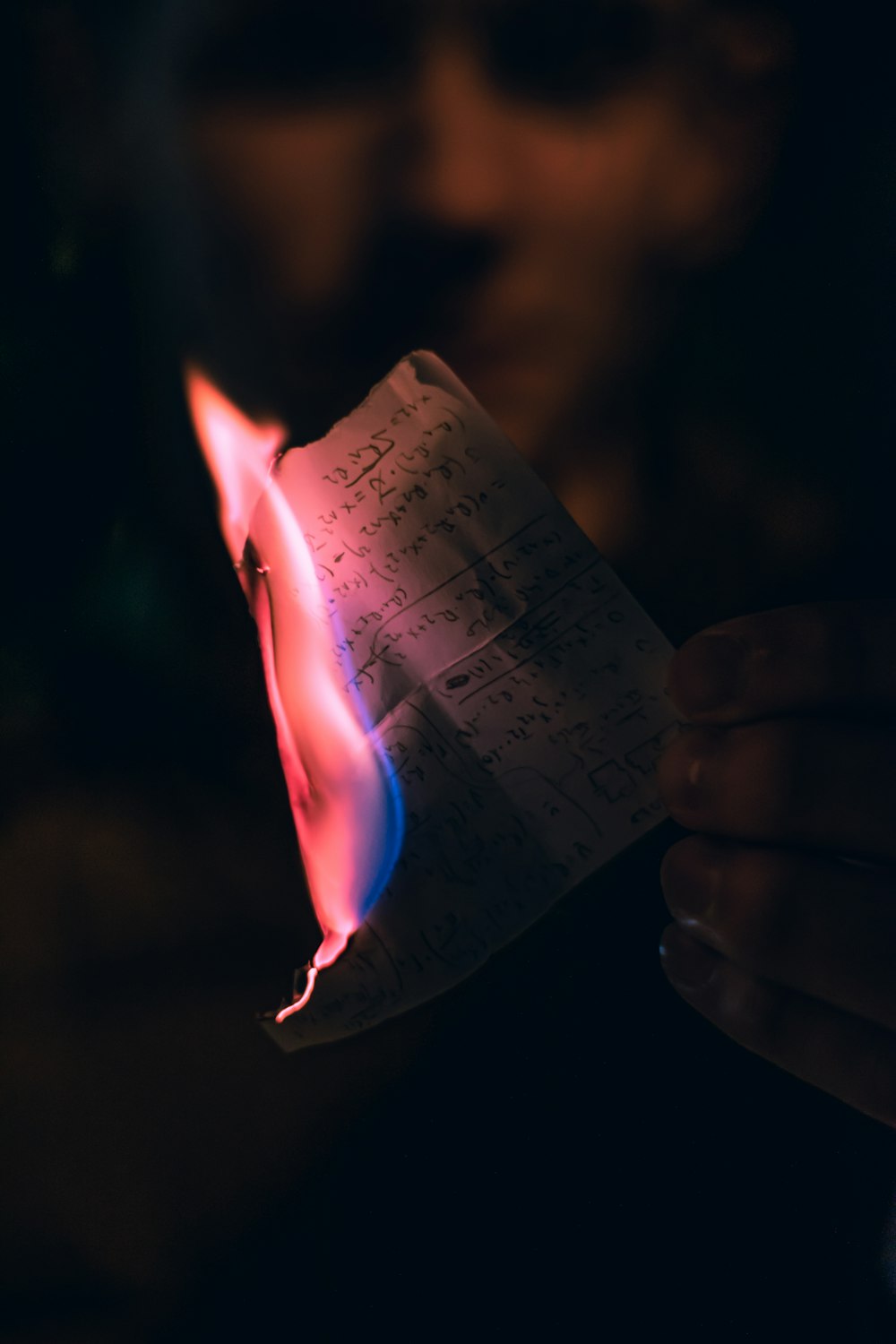 person burning paper with writing .