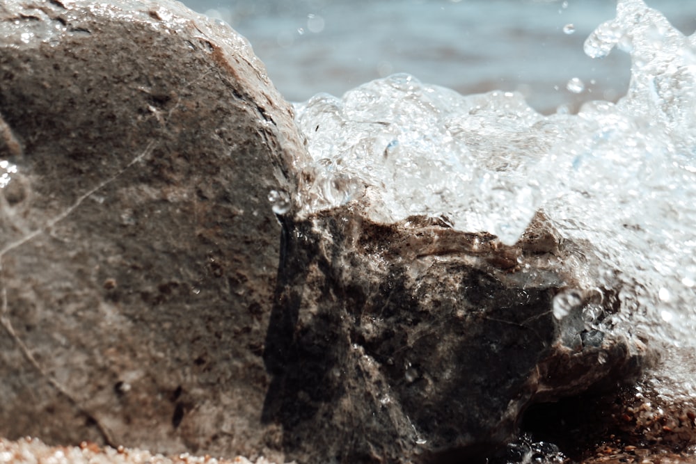 water crashing on rocks during daytime