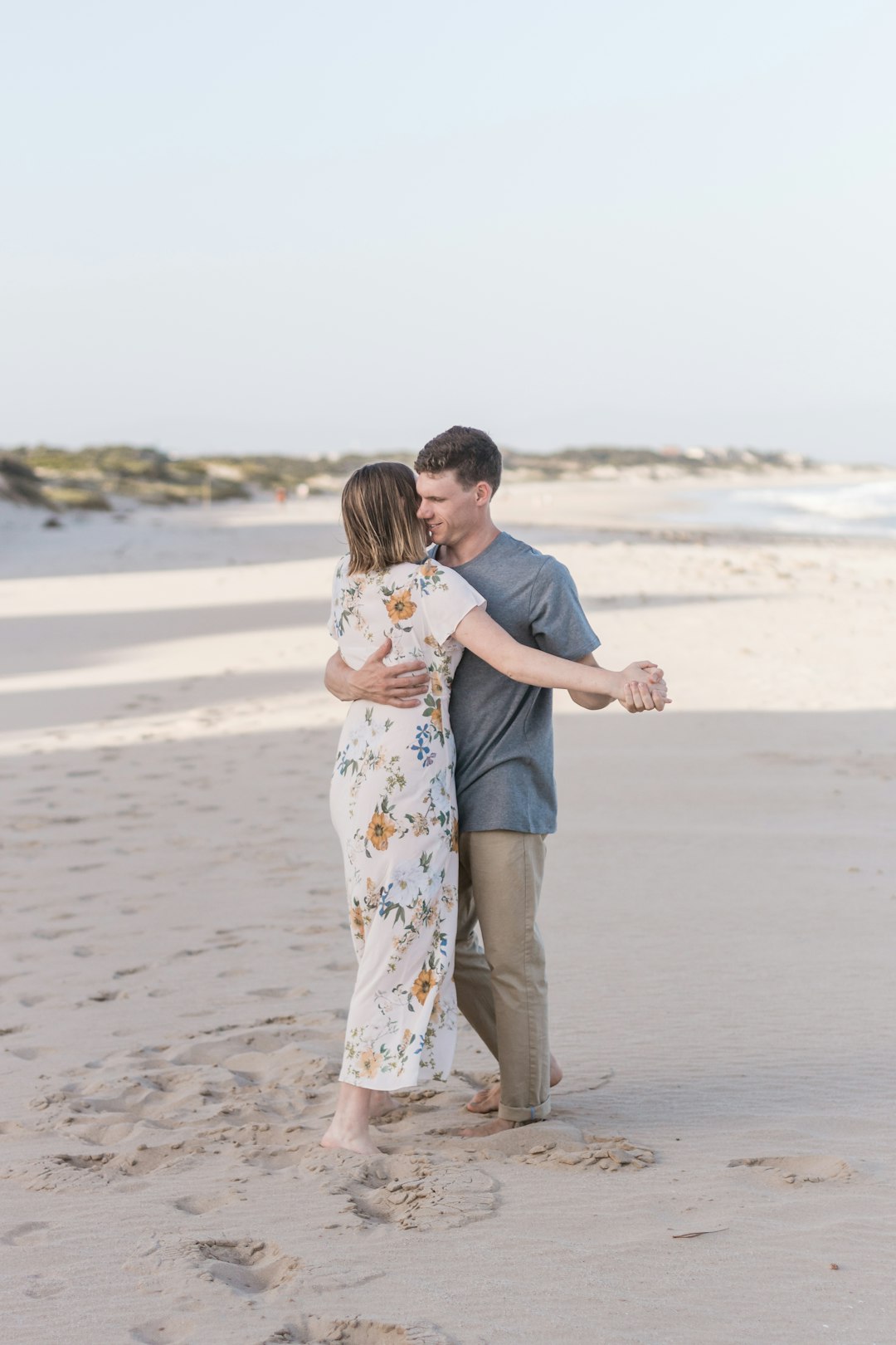 man and woman standing near ocean at daytime