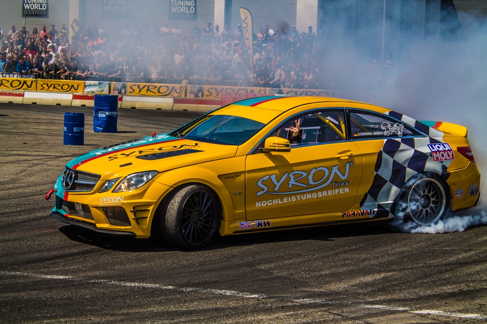 yellow Mercedes-Benz coupe on track