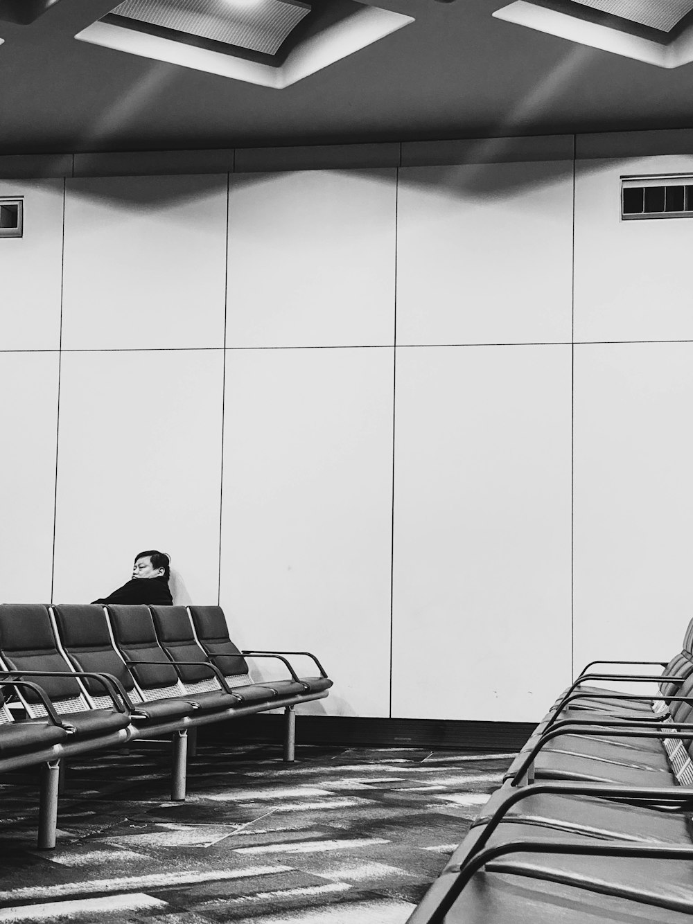 grayscale photography of person sitting on chair