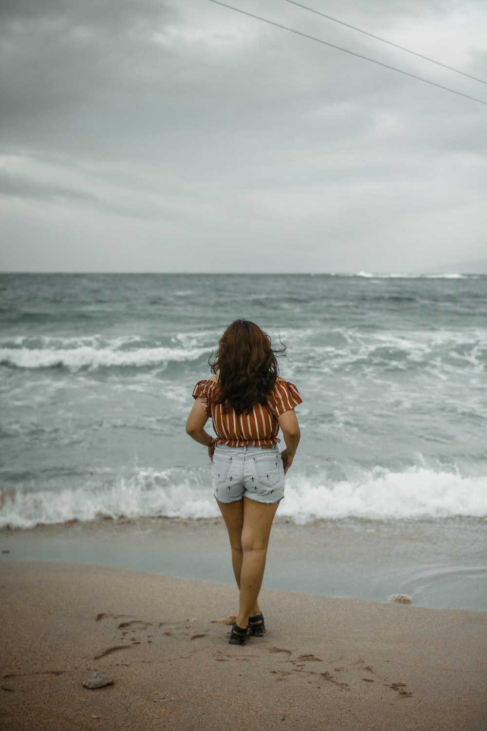 woman standing on shore during daytime