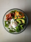 Bright, colorful bowl of mixed greens with cherry tomatoes and avocado slices