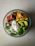 A vibrant, colorful salad bowl topped with fresh greens, cherry tomatoes, and avocado slices.