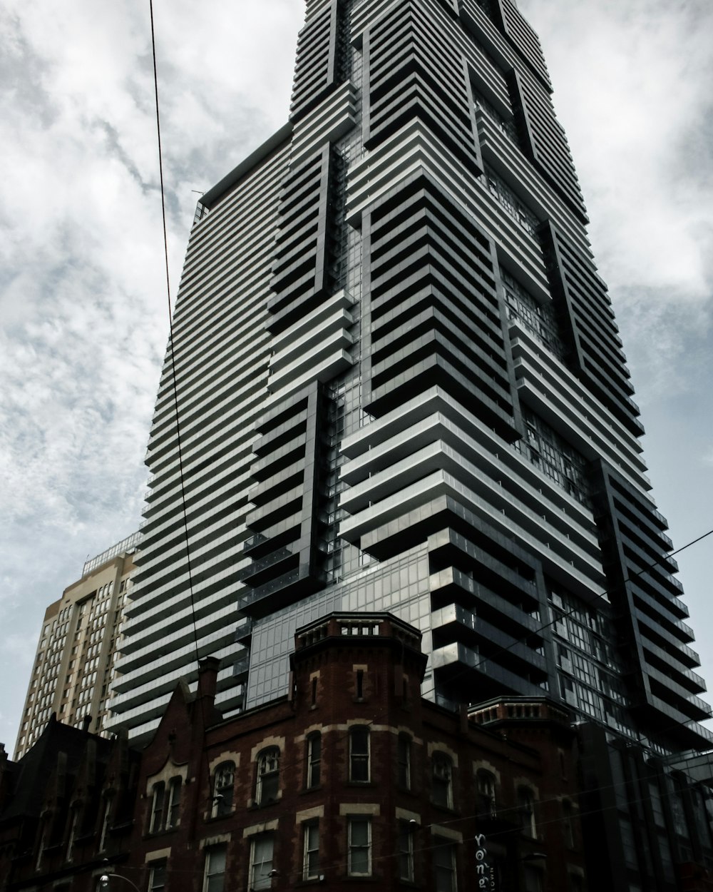 흰색과 푸른 하늘 아래 회색과 갈색의 고층 건물의 로우 앵글 사진