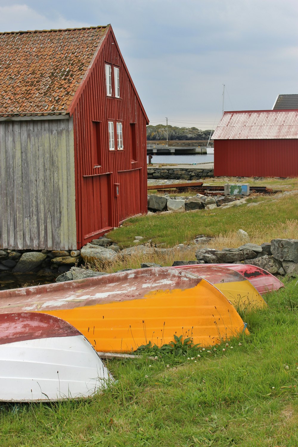 boats and buildings on grass field during day