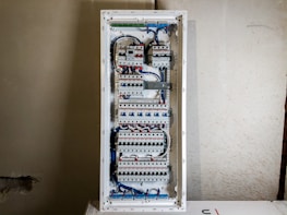 An electrician installing a new circuit breaker panel in a modern home.
