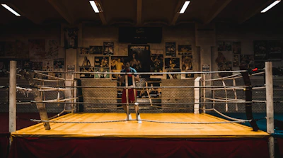 A sleek boxing ring surrounded by cushioned mats and modern lighting, capturing the energy of Fight Haus.