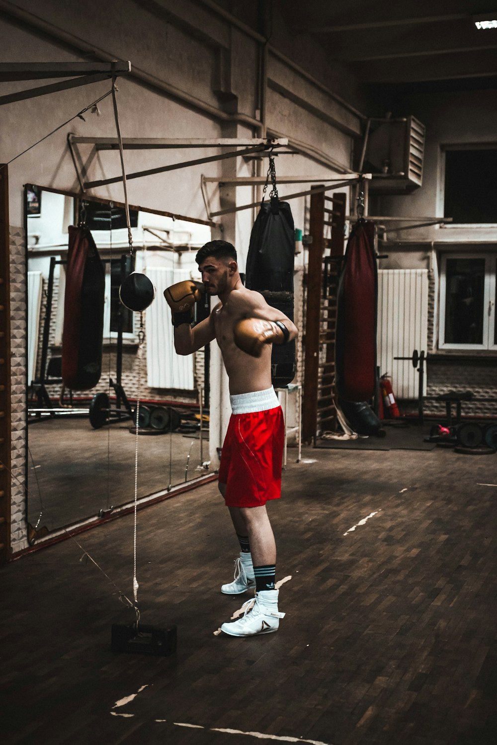 homme portant un short rouge à l’intérieur du gymnase