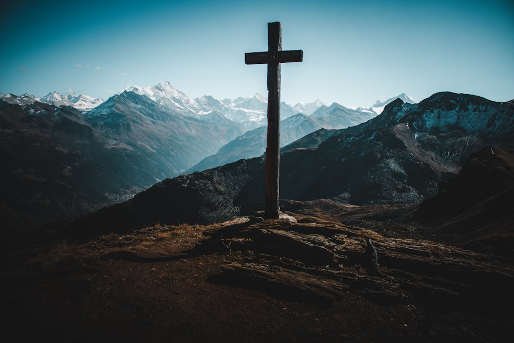 cross on rocky mountain during day