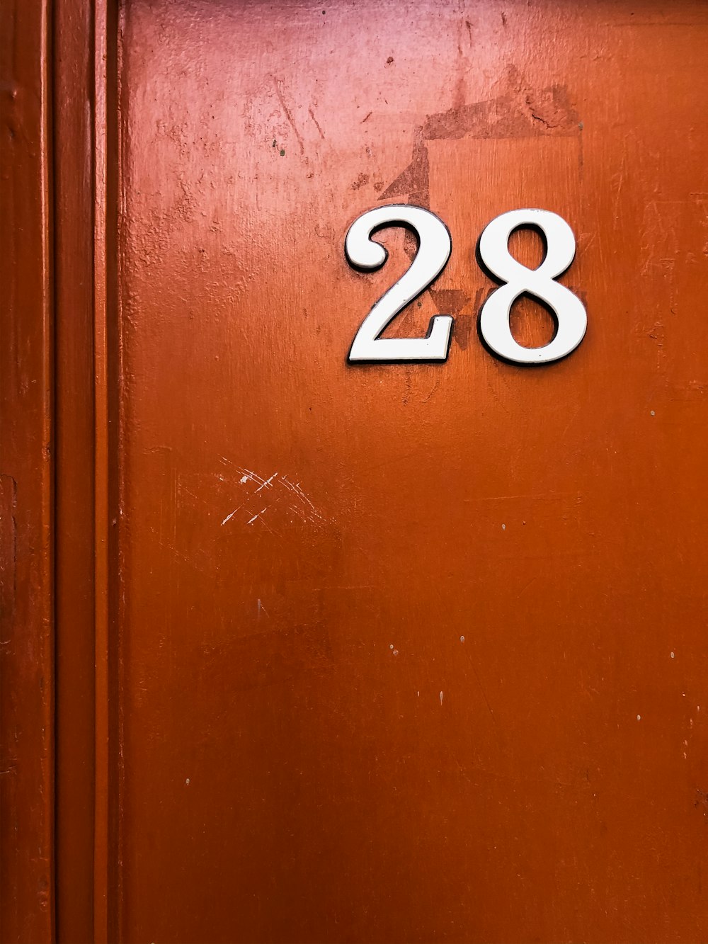 red painted wooden door with 28 number