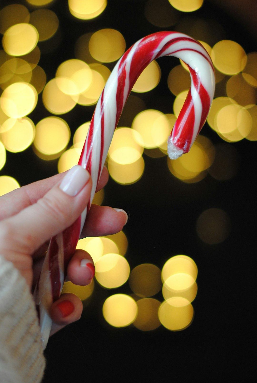 person holding red and white candy cane