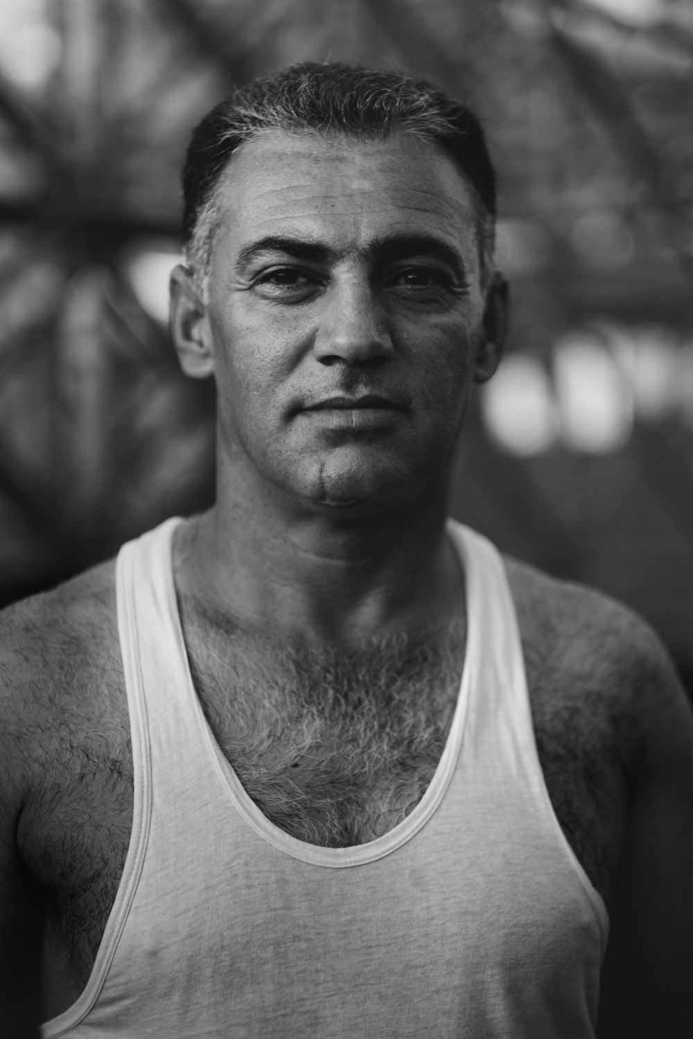 grayscale photography of man wearing tank top standing
