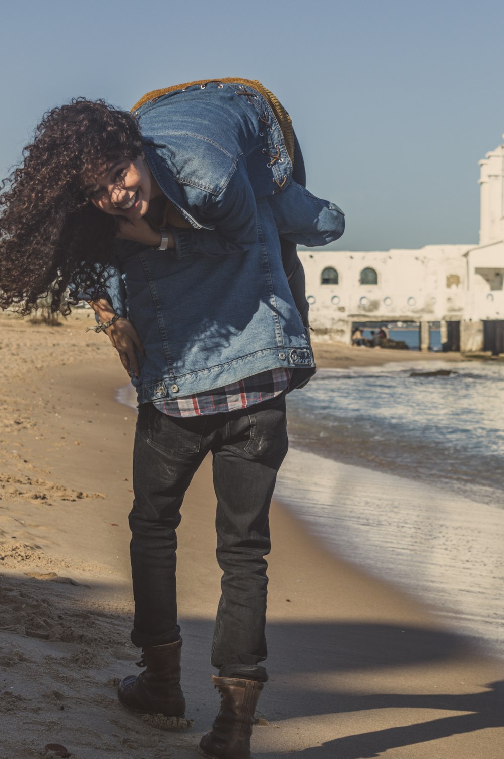 man carrying woman walking on seashoire