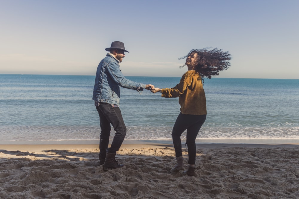 man and woman standing on seashore