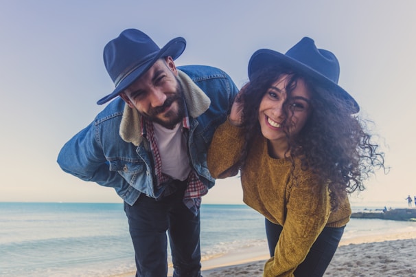 Close-up of a couple laughing while posing with funny hats and glasses in the photobooth.