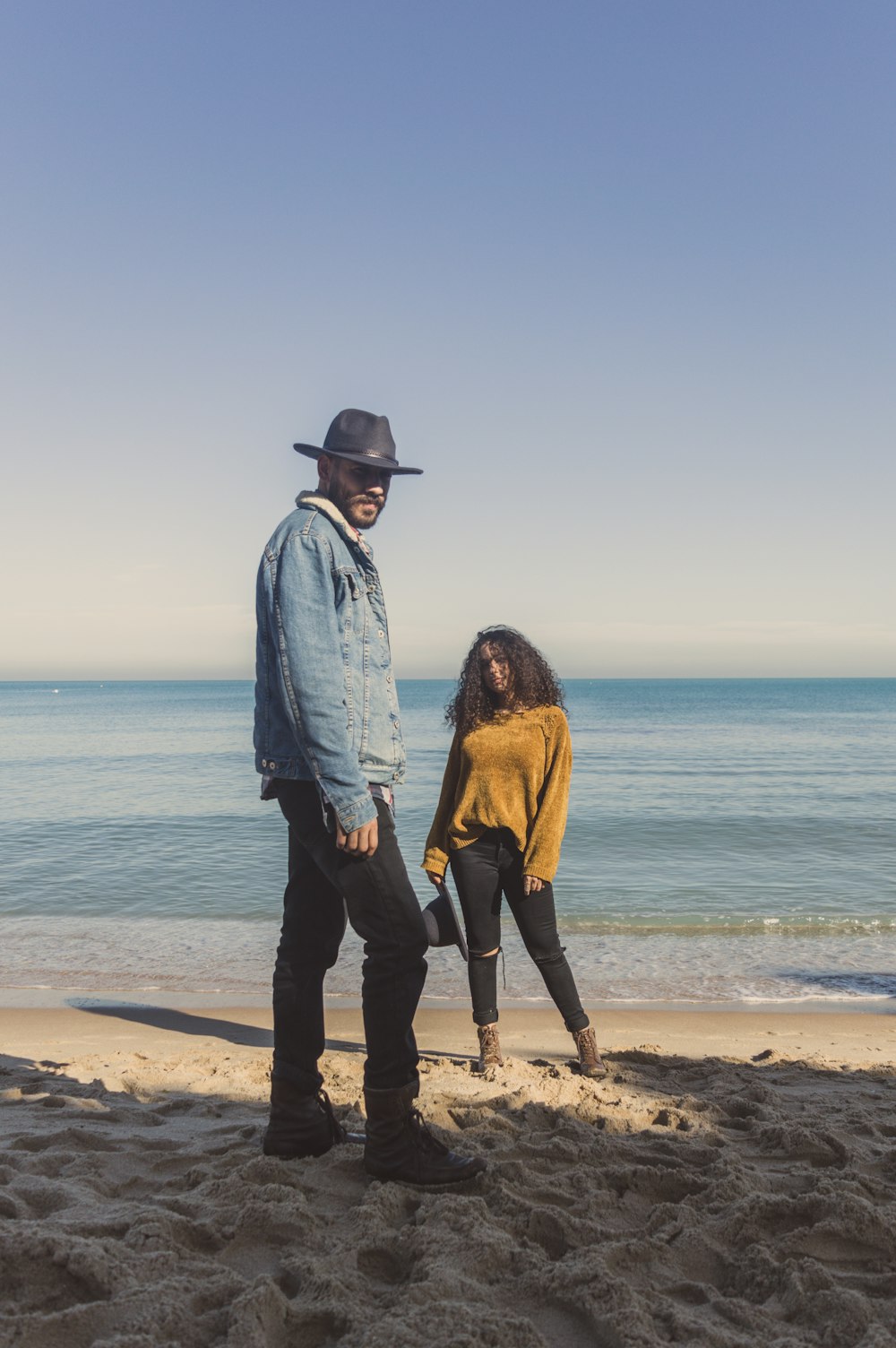 man standing on seashore near woman